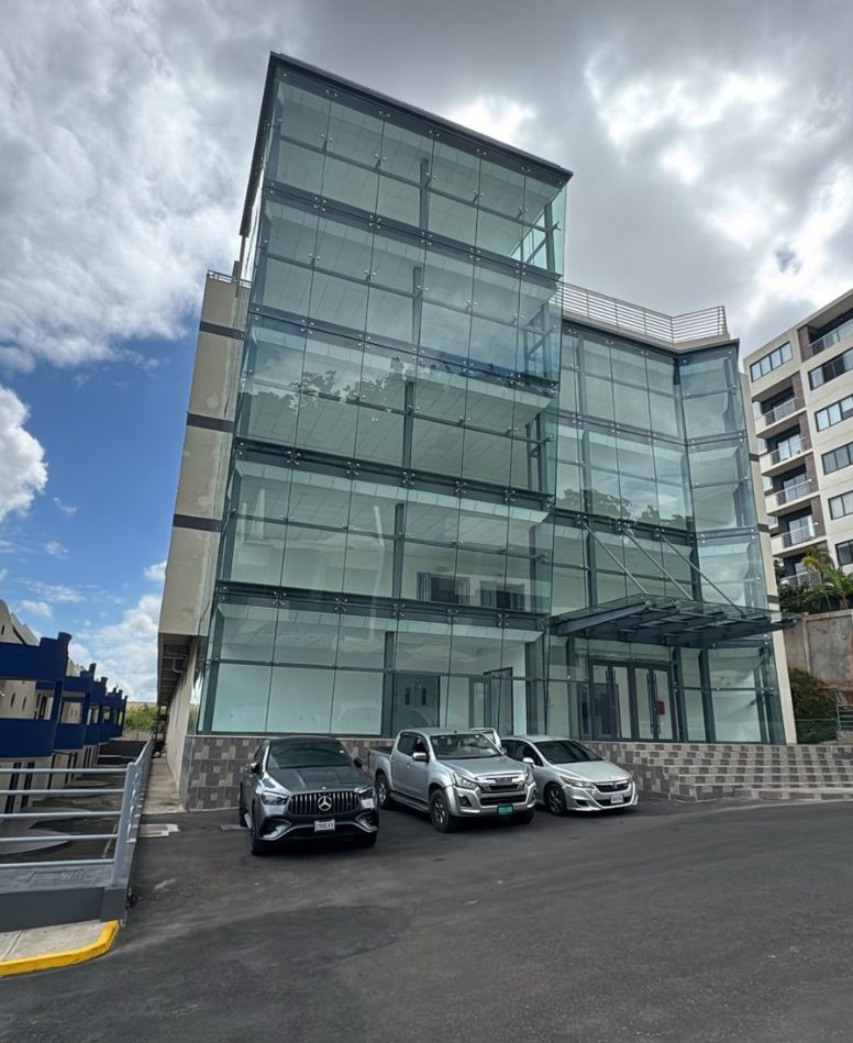 Completed Block E with its four-storey glass curtain wall and entrance canopy